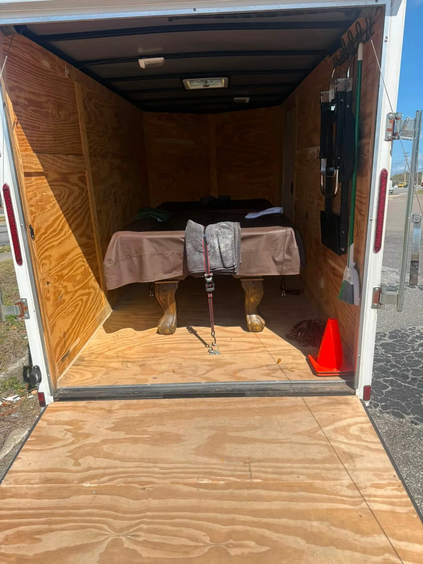 Pool table loaded inside an enclosed trailer with pads and straps